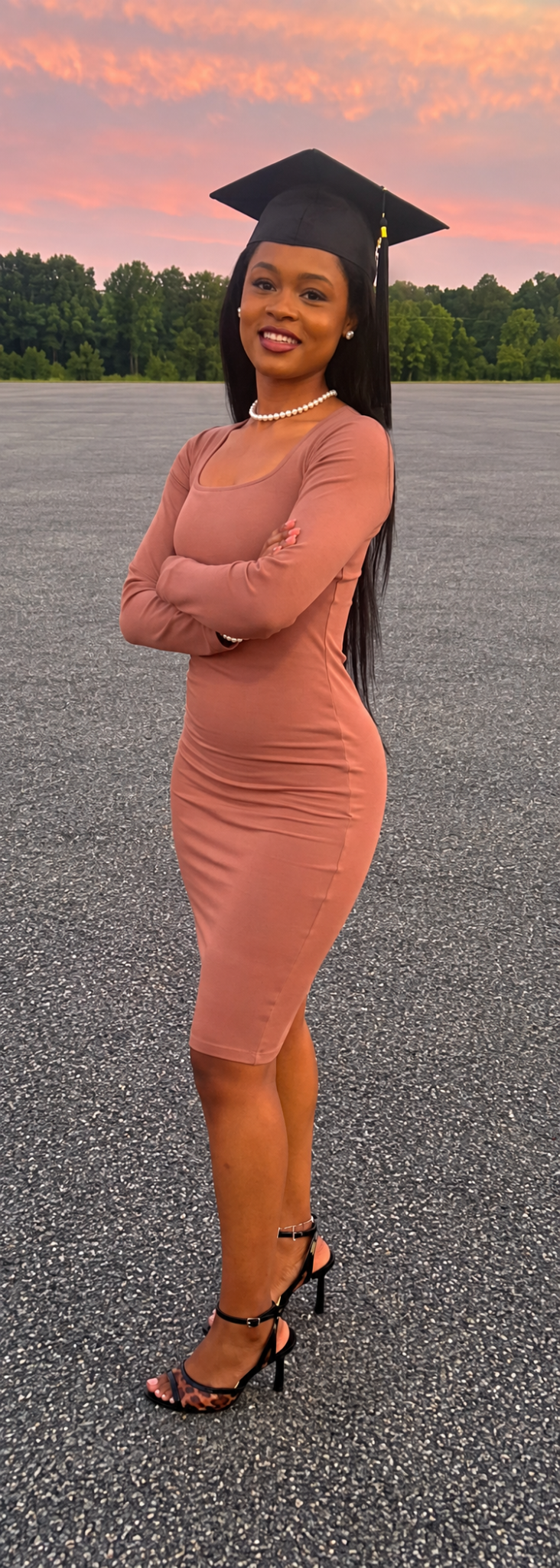 Gioi in a graduation cap, brown dress, pearl necklace and leopard heels at sunset